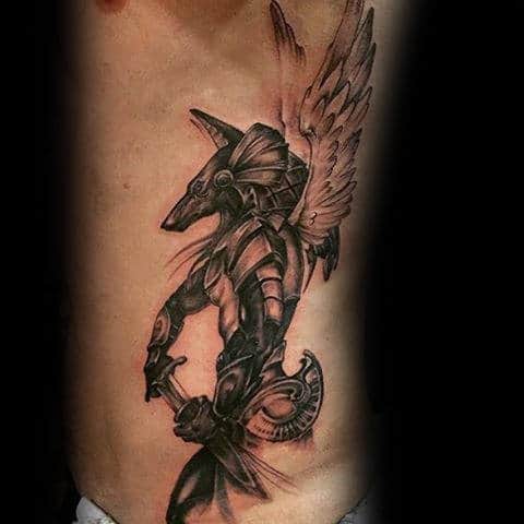 Anubis With Sword And Wings Male Rib Cage Tattoos