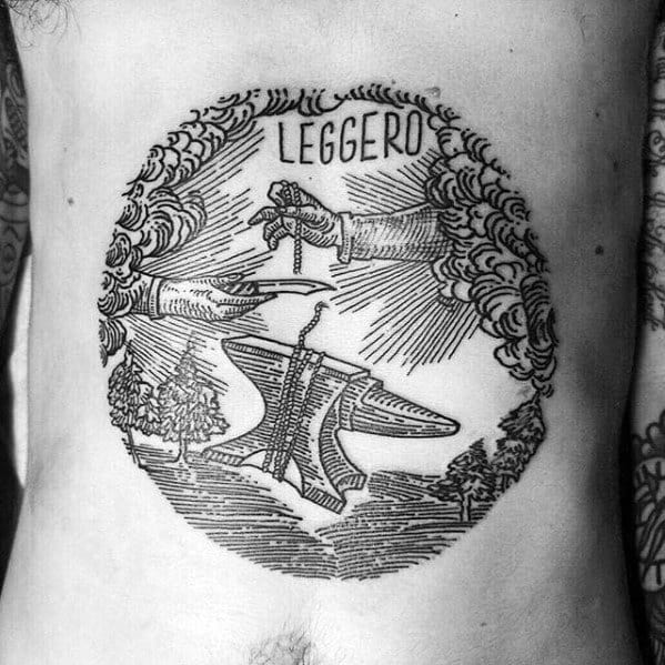 Vintage-style anvil tattoo with "LEGGERO" text, featuring divine hands lowering a thread onto the anvil, framed by clouds and trees.