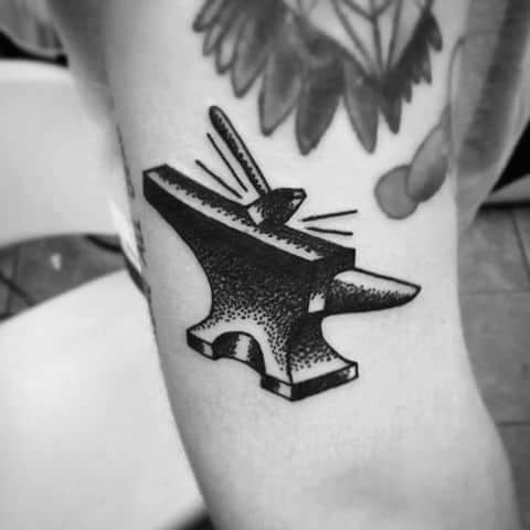 Bold black anvil tattoo with a hammer striking it, using dotwork shading and motion lines to emphasize impact.