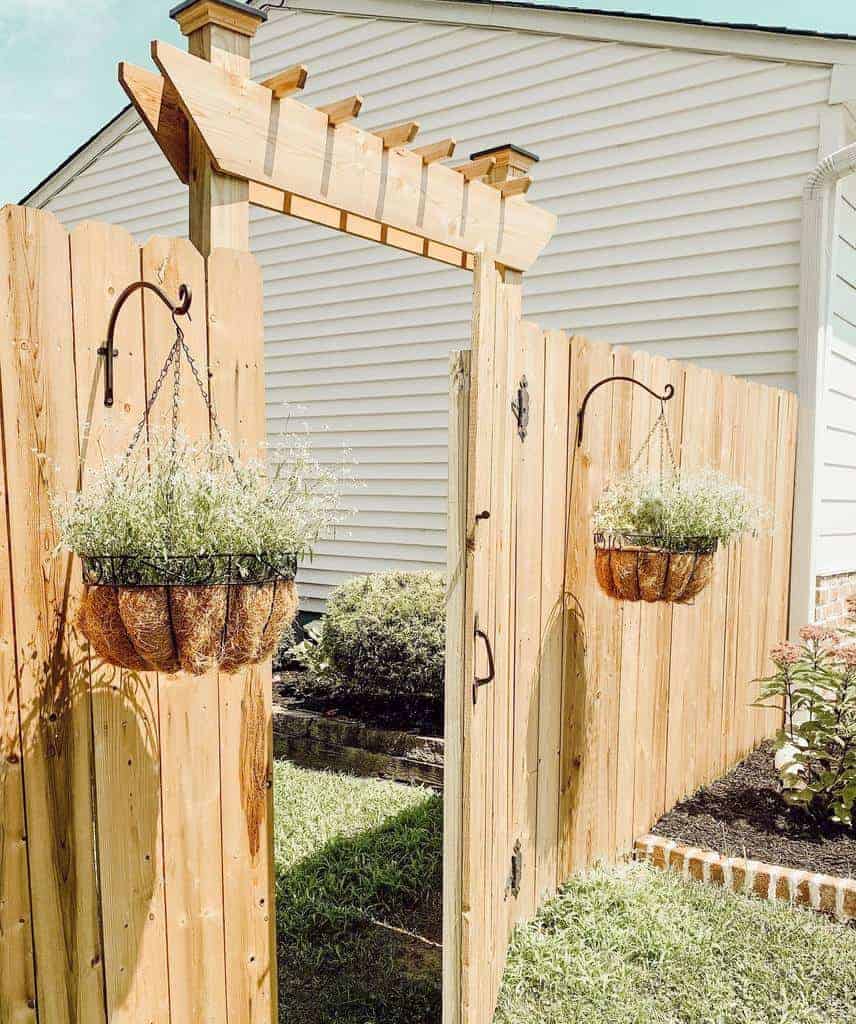 wood arbor garden gate and fence hanging plants