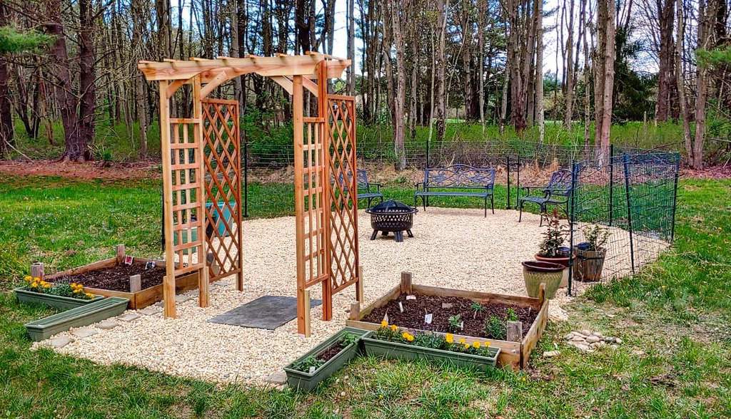 stained wood arbor garden trellis small gravel area blue garden benches