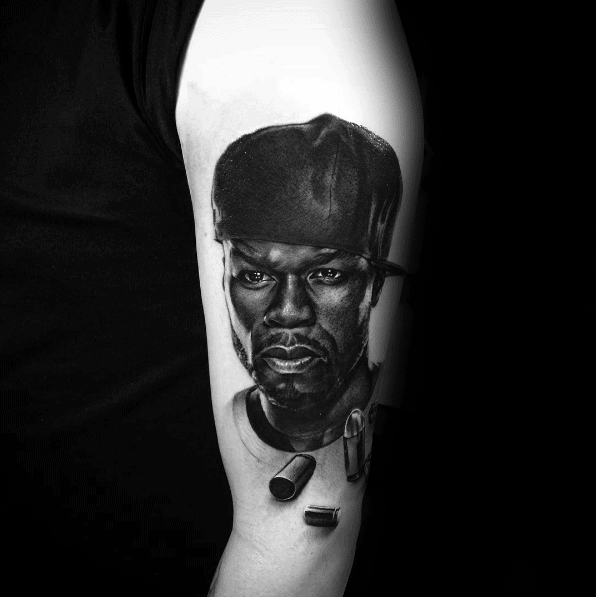 A hyper-realistic tattoo of 50 Cent, capturing his confident gaze with added details like bullets for a bold design