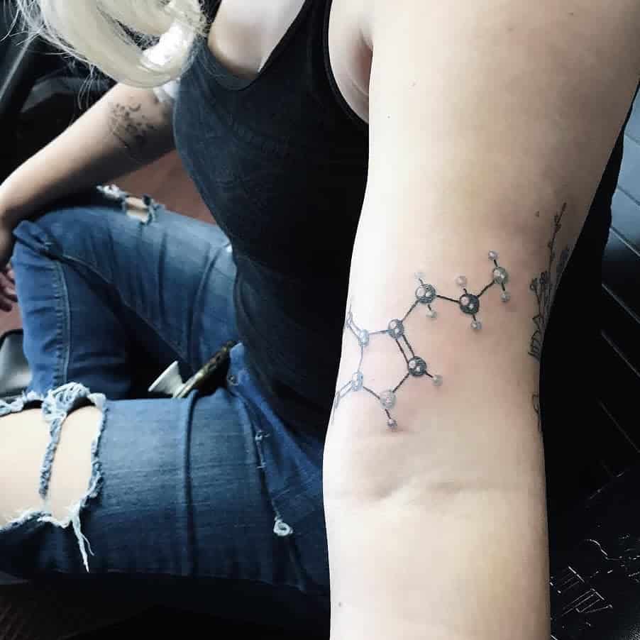 A woman with a serotonin chemical structure tattoo on her arm 