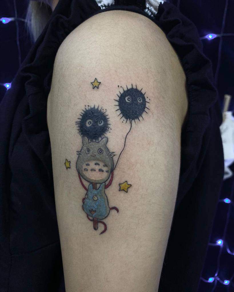Totoro arm tattoo with soot sprite balloons and stars, adding a playful, whimsical touch to this Studio Ghibli tribute
