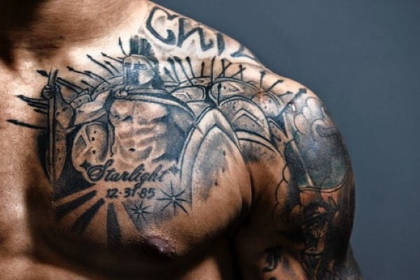 Chest tattoo of a warrior with text "Starlight" and a date on a muscular person