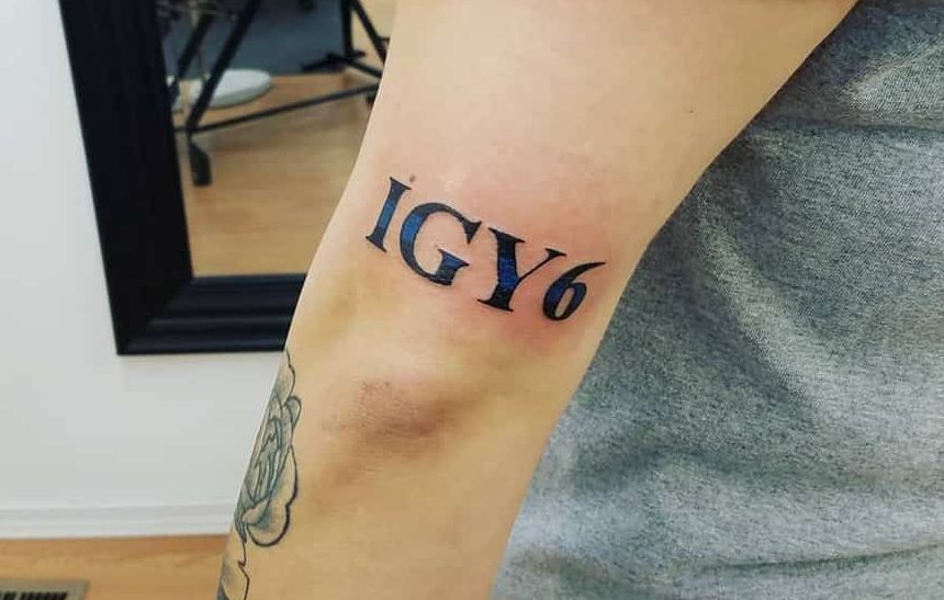 Person's arm with a tattoo reading "IGY6" in bold black letters