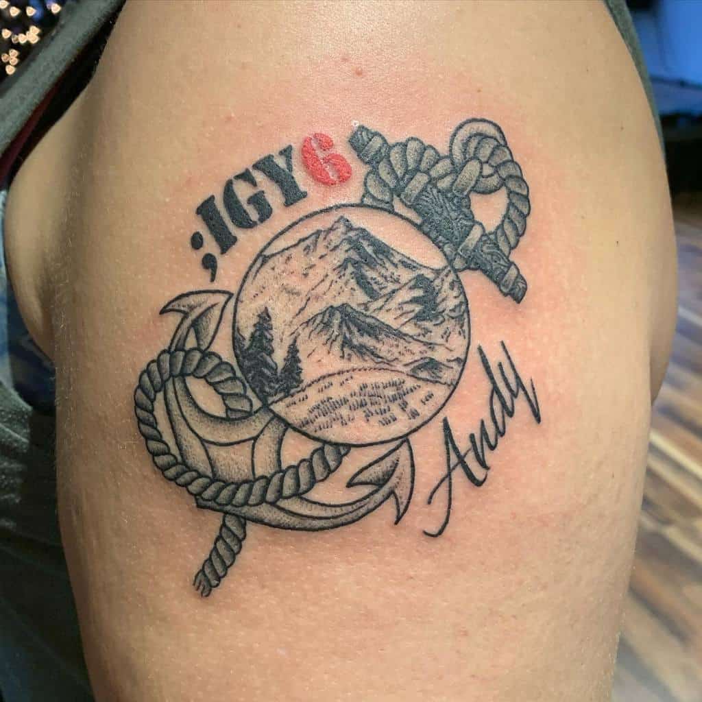Tattoo of an anchor, rope, and mountains with ";IGY6" and "Andy" text on a man's arm
