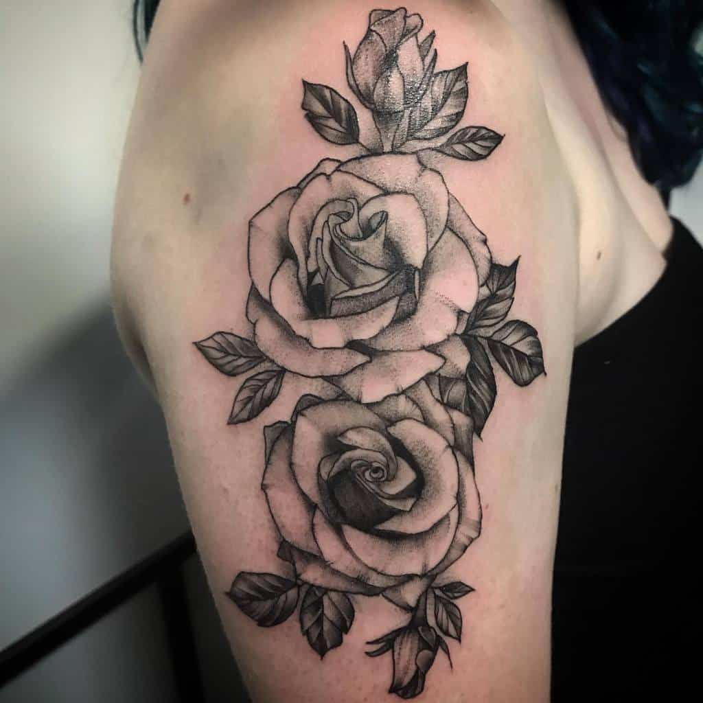Tattoo of three roses and lush leaves on a woman's upper arm