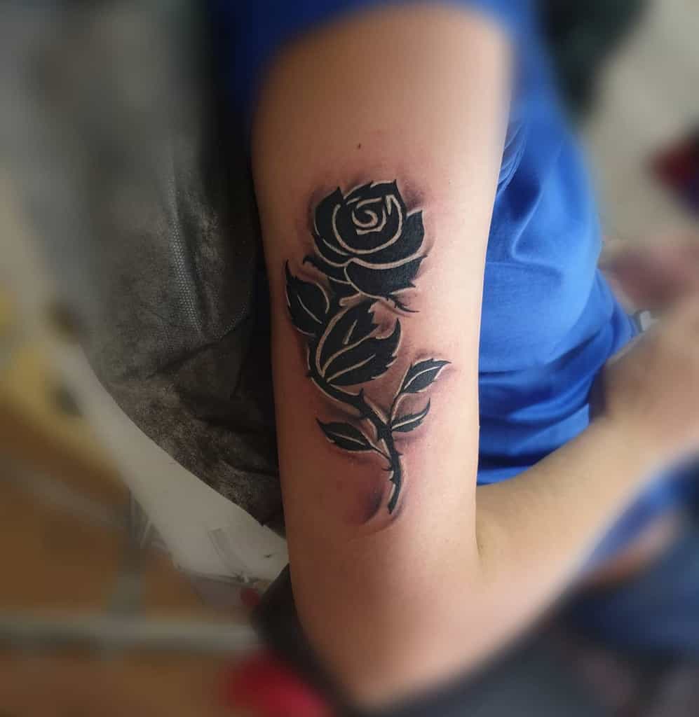 Armed with a striking black and white rose tattoo on the forearm