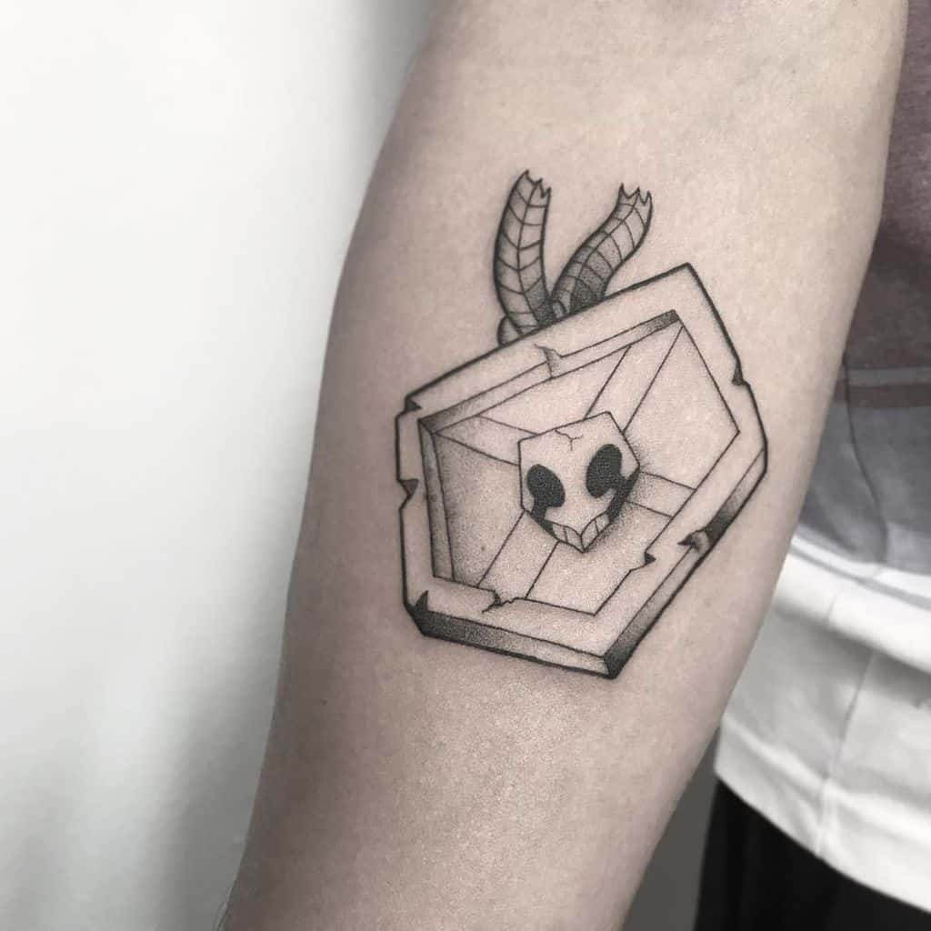 Black and grey tattoo of Bleach’s Hollow mask with horns, featuring geometric and shaded elements
