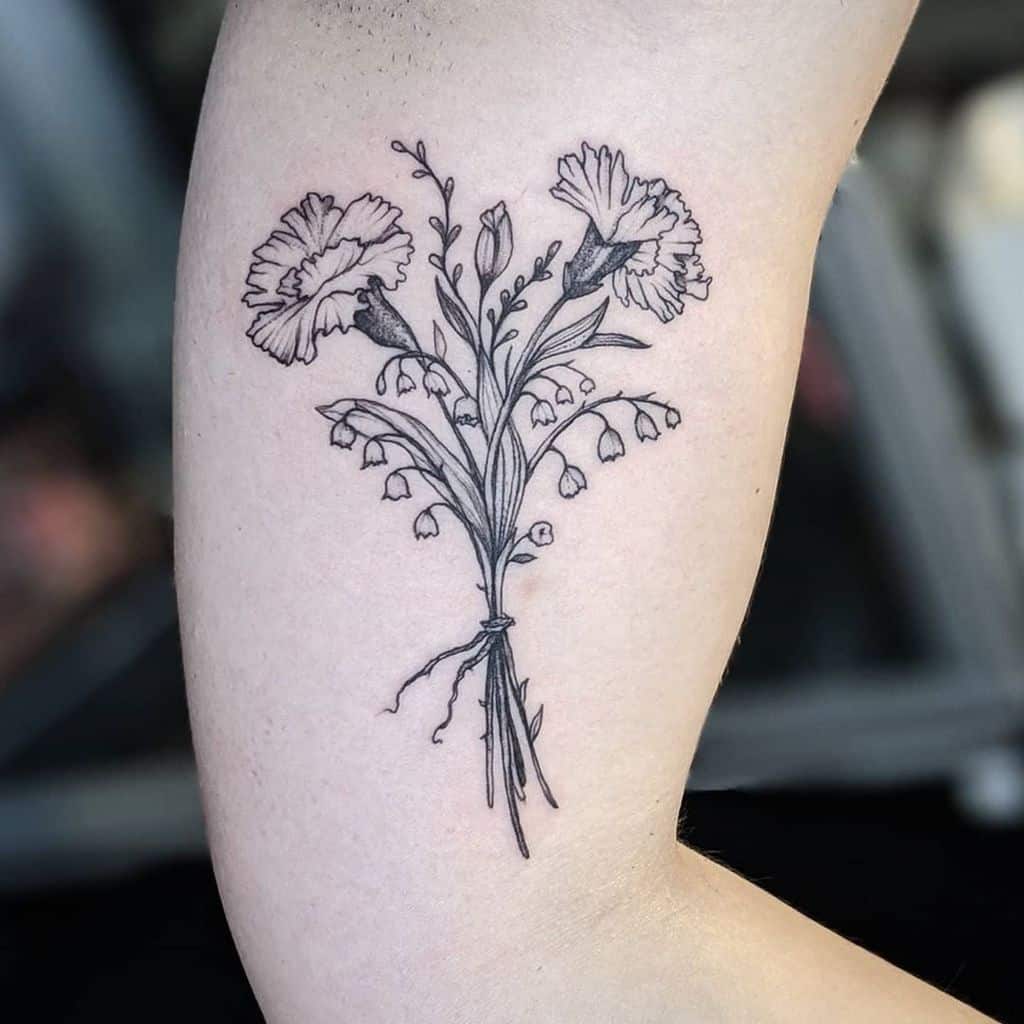 Tattoo of a floral bouquet, featuring carnations and lily of the valley flowers in black ink