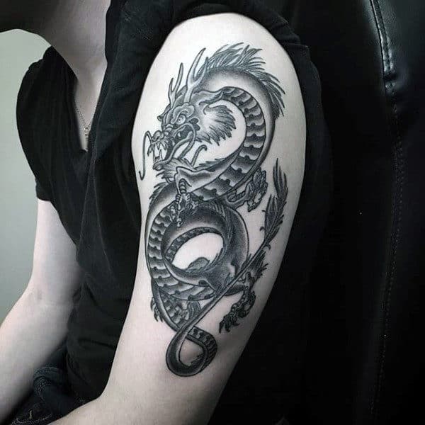 Black and gray dragon tattoo on upper arm