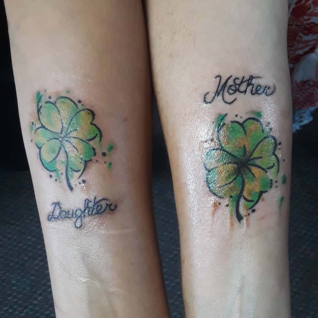 Matching mother-daughter tattoos featuring watercolor-style four-leaf clovers