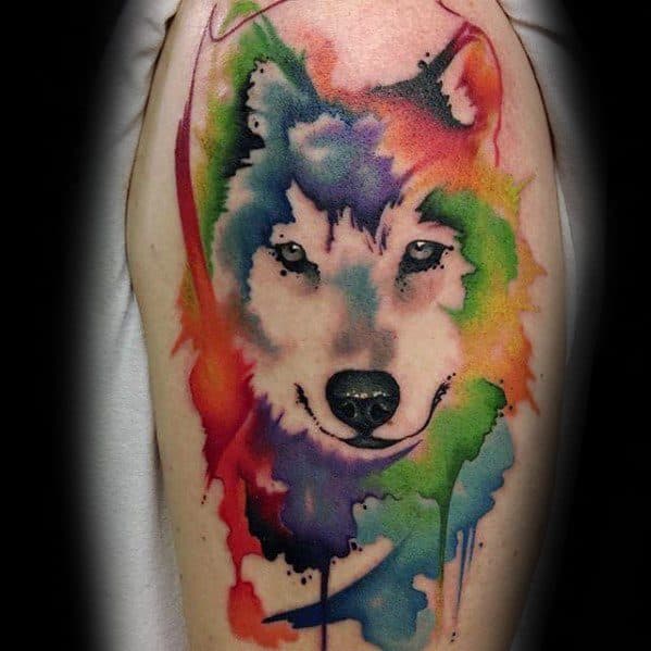 Wolf tattoo with bold rainbow watercolor splashes and dripping paint effect, blending fierce expression with vivid abstract tones.