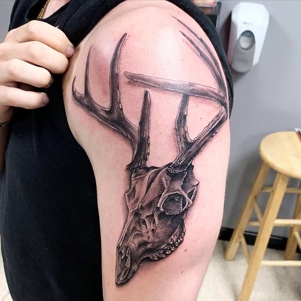 Tattoo of a majestic deer skull with antlers on an upper arm