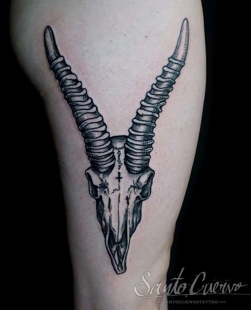 Detailed deer skull tattoo with large curved horns, creating a bold and intricate design on the thigh