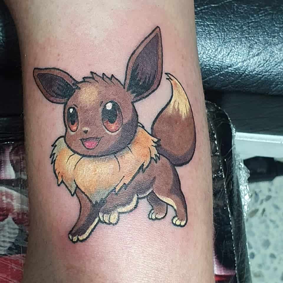 Bright and lively Eevee tattoo with rich fur detailing and expressive eyes, bringing a classic and cheerful look to the design