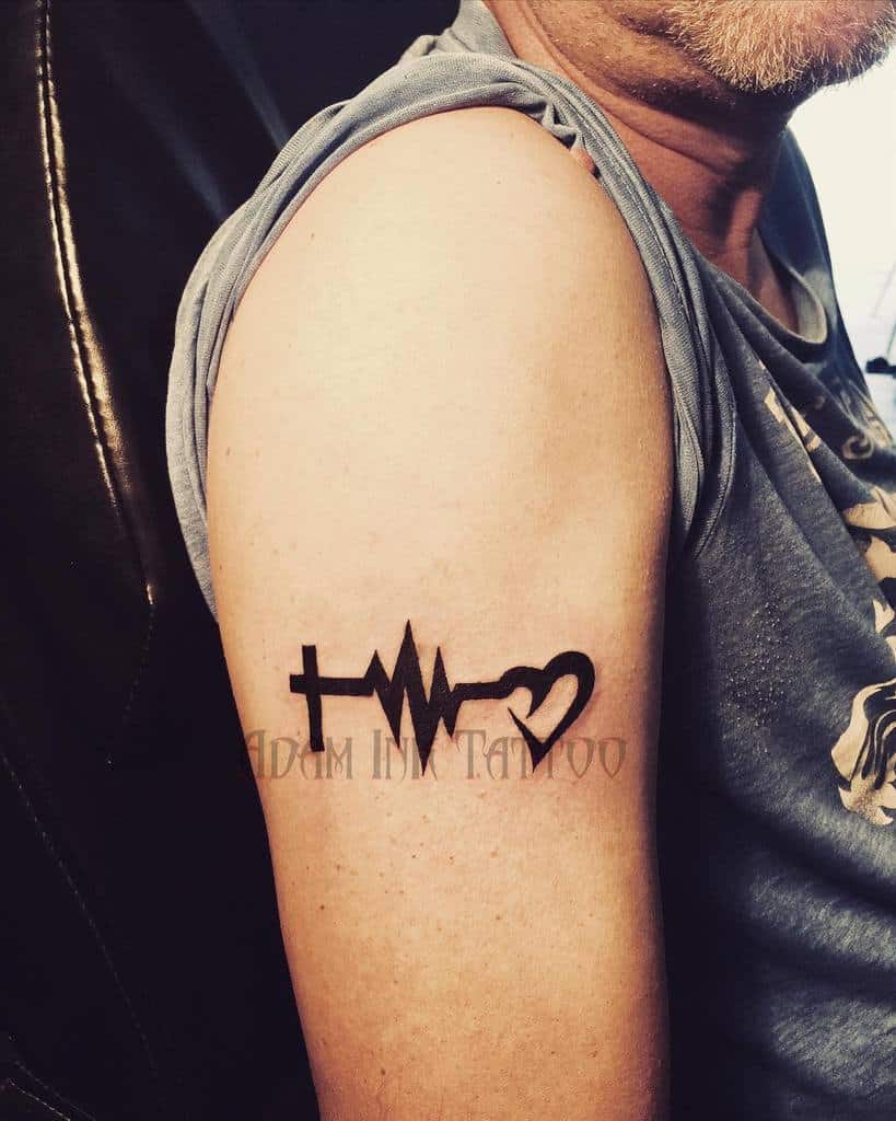 Arm tattoo with a cross, heartbeat line, and heart design, symbolizing hope and faith intertwined with love
