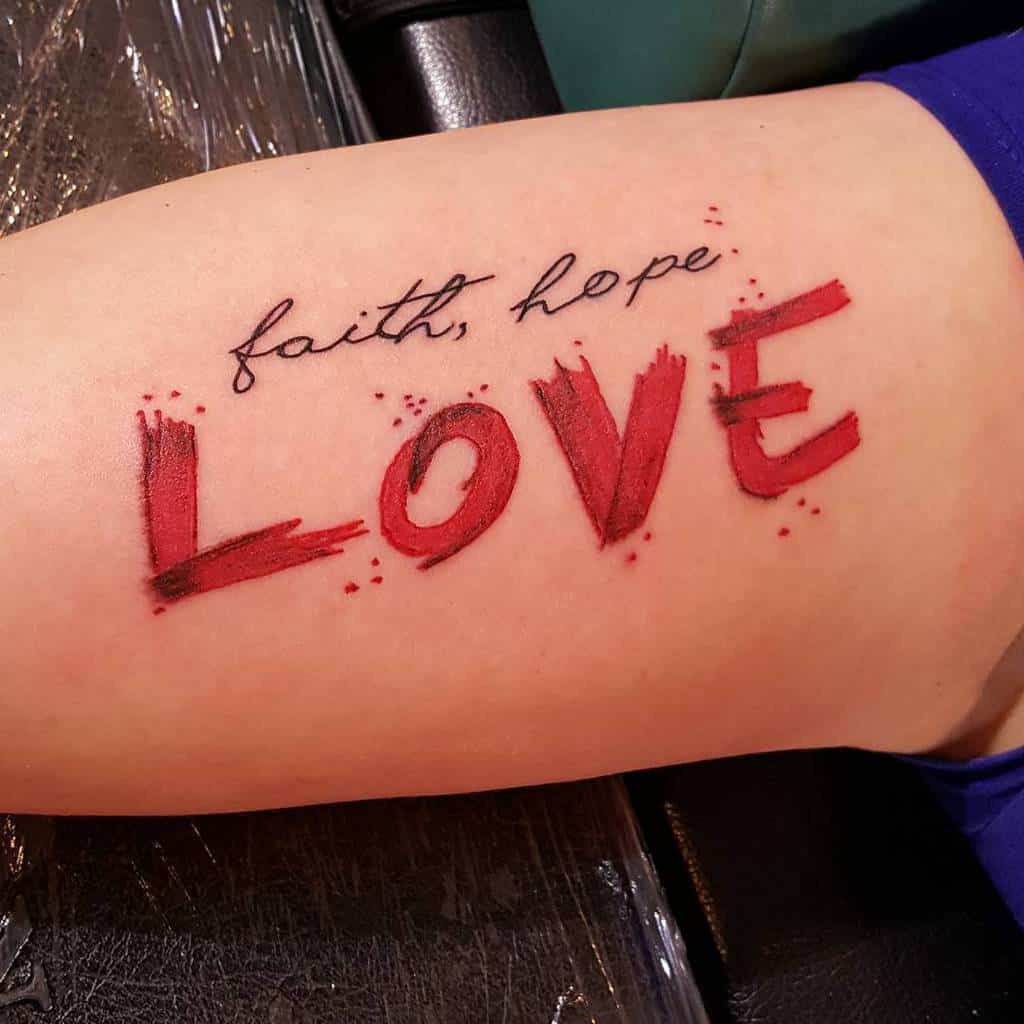 Tattoo on skin with the words "faith, hope, love" in black and red ink