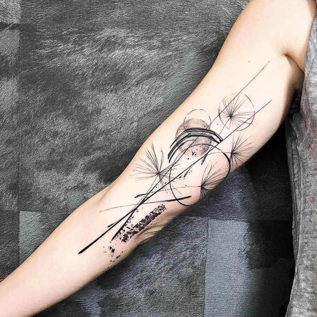 Abstract tattoo on a forearm with geometric lines, circles, and dandelion-like shapes in black ink