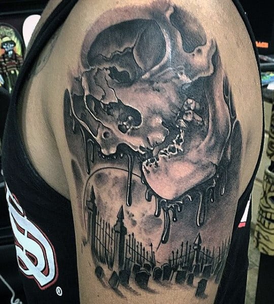 Arm tattoo of a melting skull with an eerie graveyard scene underneath