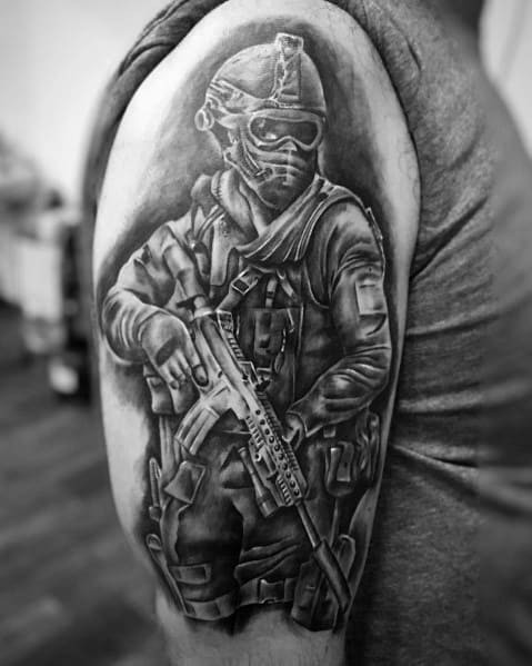 Realistic Call of Duty soldier tattoo in black and grey, featuring a heavily armed operator with tactical gear and a rifle on the upper arm.