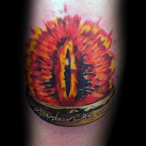 A tattoo depicting the fiery Eye of Sauron hovering ominously above a gold ring inscribed with mysterious runes