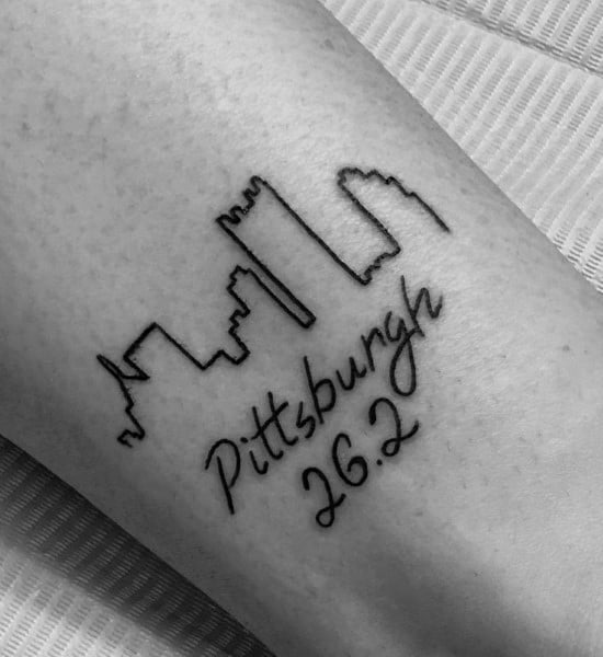 Minimalist Pittsburgh skyline tattoo with cursive “Pittsburgh 26.2,” celebrating the city and the marathon accomplishment.