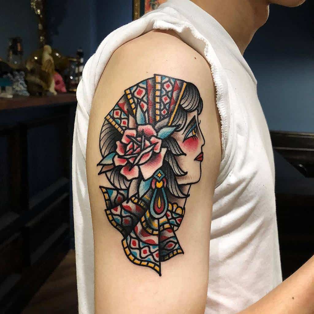 A colorful tattoo of a gypsy woman's profile adorned with a vibrant rose graces the upper arm