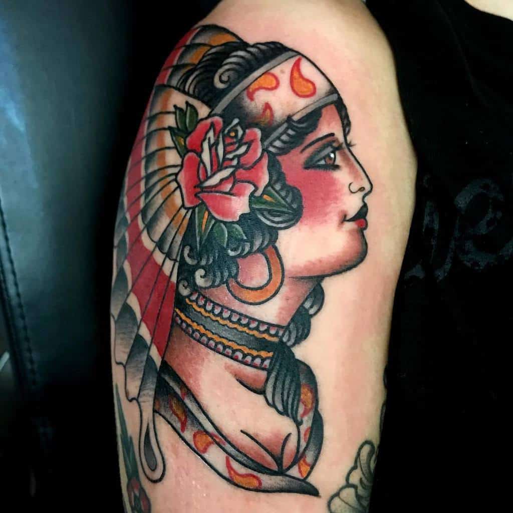 Tattoo of a gypsy woman in profile, adorned with feathers and a rose nestled in her hair