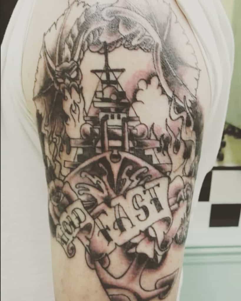 Tattoo of a ship with "HOLD FAST" text on a man's upper arm