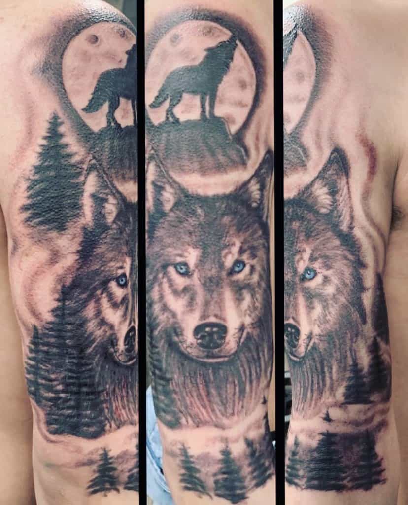 Tattoo of a blue-eyed wolf, featuring a howling silhouette against a luminous full moon, encircled by majestic pine trees