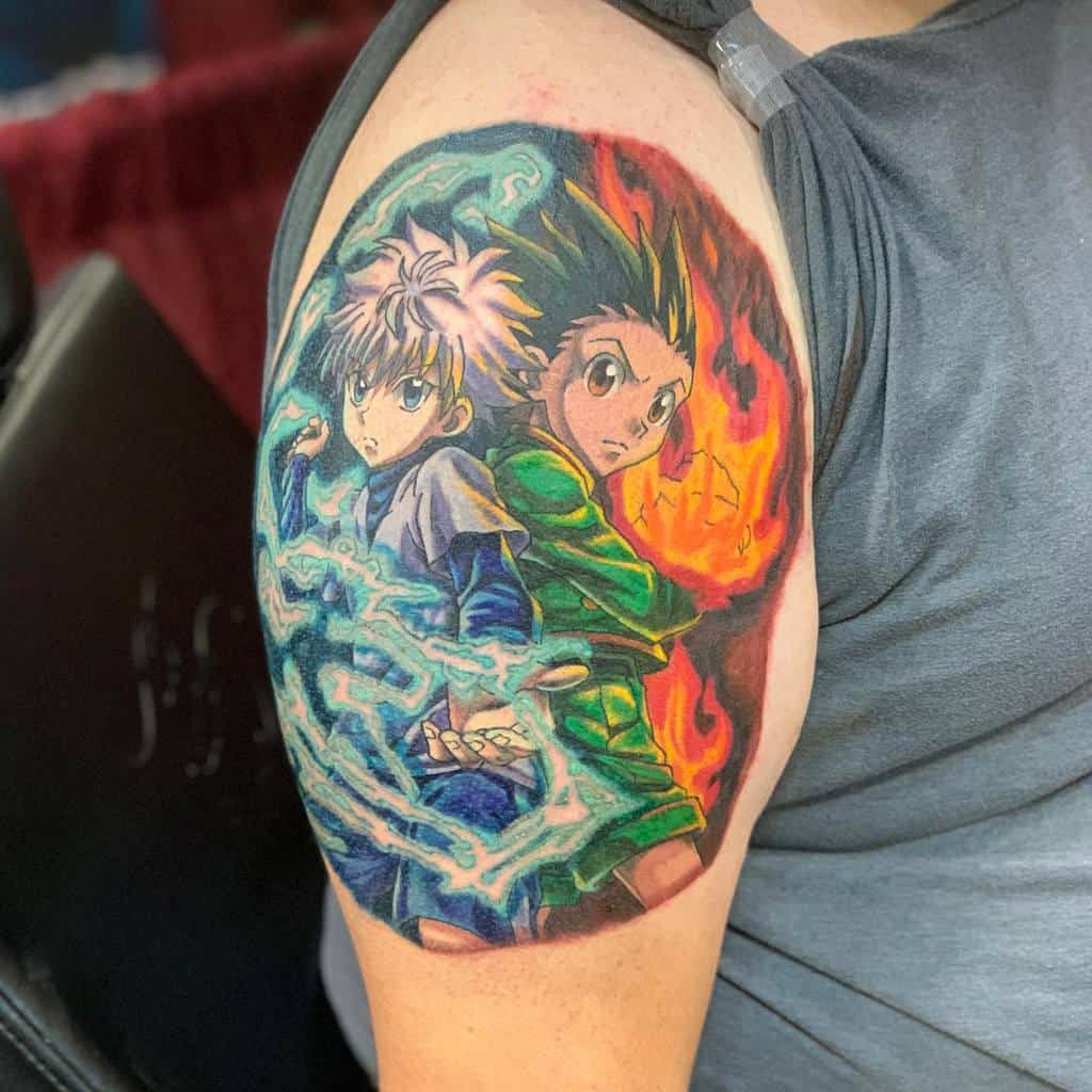 Vivid tattoo of Killua and Gon from Hunter x Hunter, showcasing their powers with electric blue and fiery red auras on the upper arm