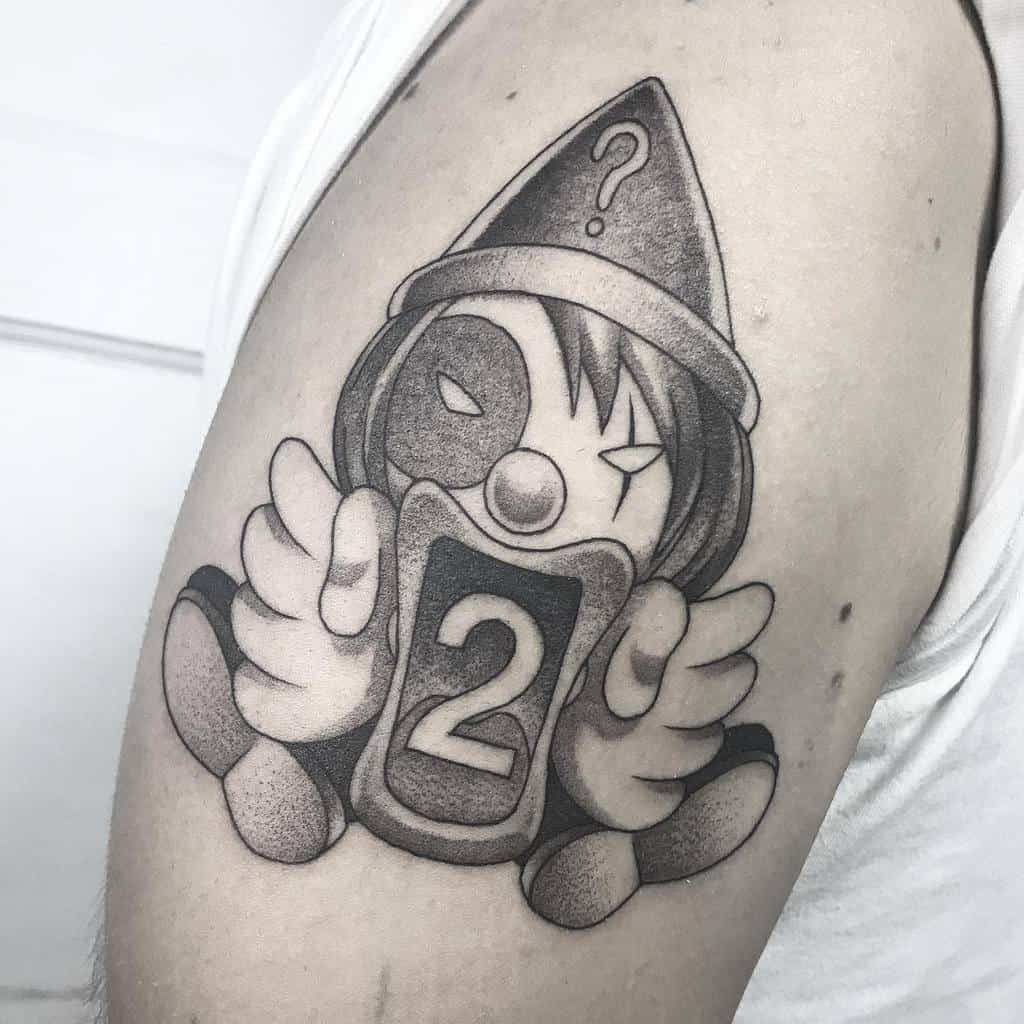 Black-and-grey tattoo of Kortopi from Hunter x Hunter, holding a card with the number 2, featuring a clown-like design with shading details