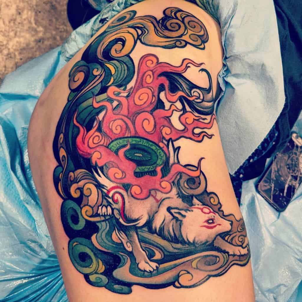Colorful tattoo of a Japanese wolf amidst swirling patterns and flames on an upper arm
