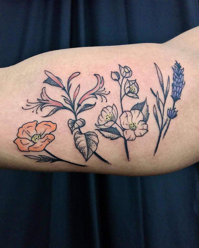 Colorful tattoo featuring various flowers and leaves on an arm