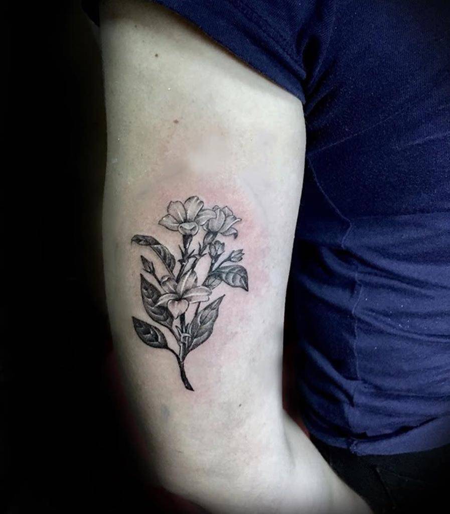 Tattoo of jasmine flowers and leaves on an arm