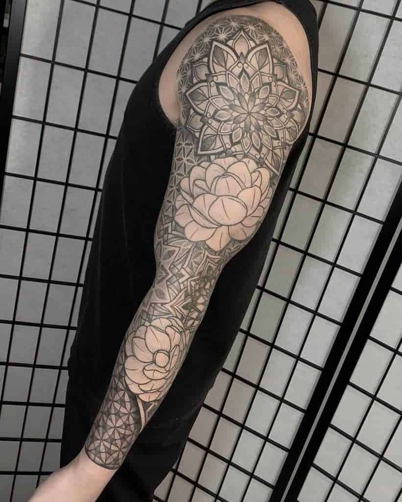 Intricate geometric sleeve tattoo featuring jasmine flowers, blending bold lines and soft floral elements for a striking design