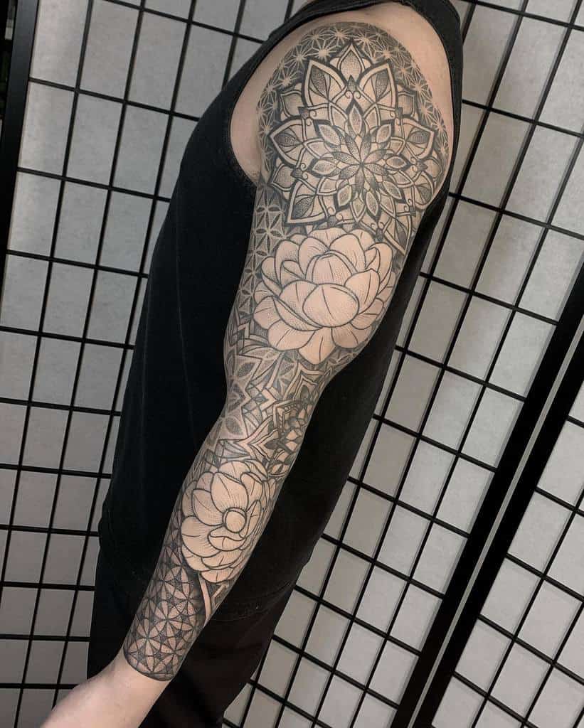 A detailed geometric and floral black ink sleeve tattoo