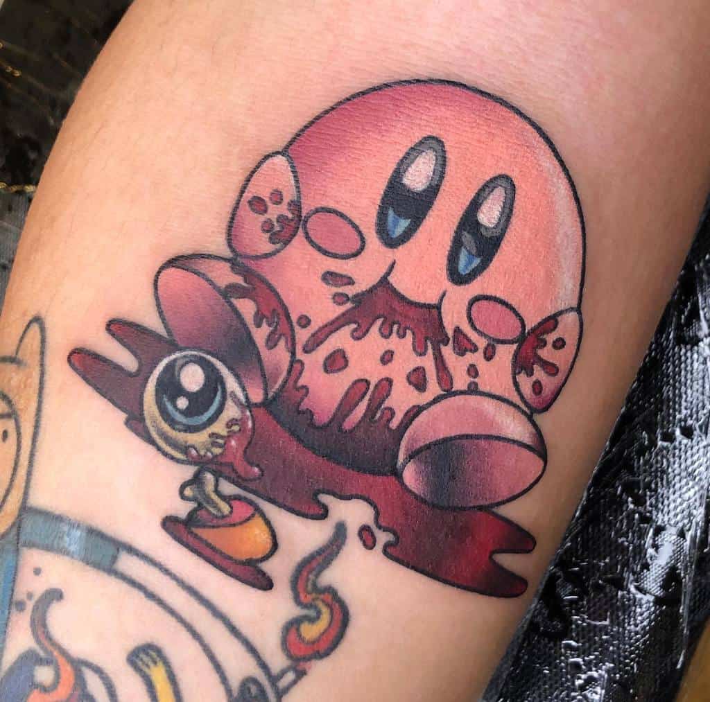 Dark-themed Kirby tattoo with a sinister smile, bloodstained mouth, and a surreal creature in a puddle