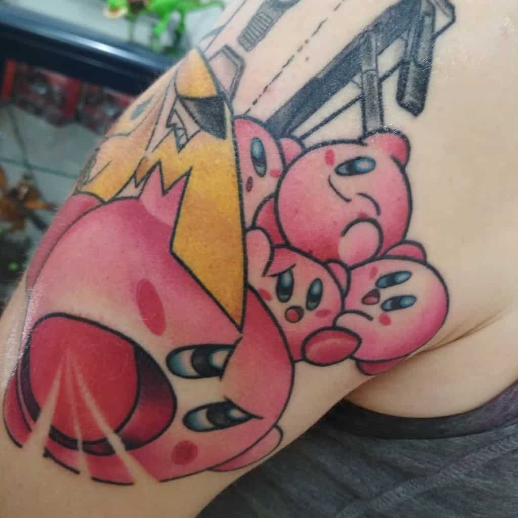 Large Kirby tattoo featuring multiple Kirbys and a dramatic inhale attack, bold colors and shading create action-packed design