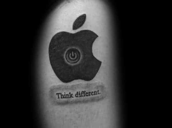 Apple logo tattoo with a power symbol at the center and the phrase "Think different." inked below in a realistic label style.