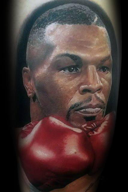 Hyper-realistic tattoo of boxing legend Mike Tyson, showcasing his focused expression and signature red boxing gloves