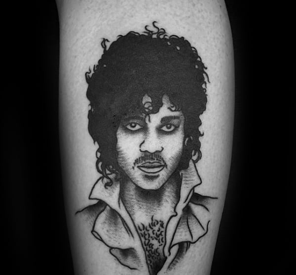 Black and white tattoo of Prince with curly hair and open shirt on skin