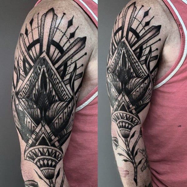 Blast over geometric black tattoo on a person's upper arm with abstract patterns and florals