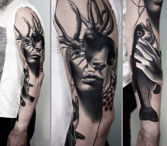 Surreal black and grey sleeve tattoo blending a woman's face with deer antlers, abstract lines, and a hand holding a fish.