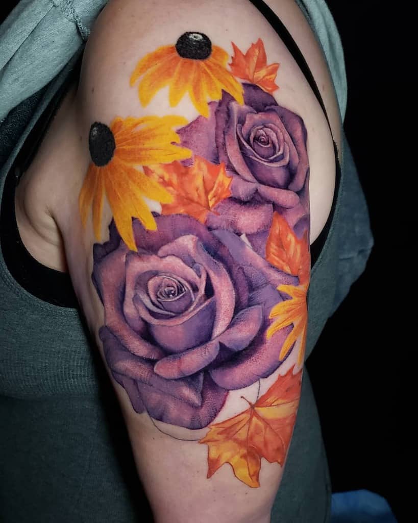 Tattoo of a purple rose and vibrant orange flowers intertwined with fall leaves on an upper arm