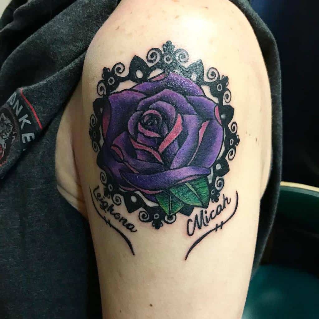 A stunning purple rose tattoo, adorned with a decorative black border, on an upper arm