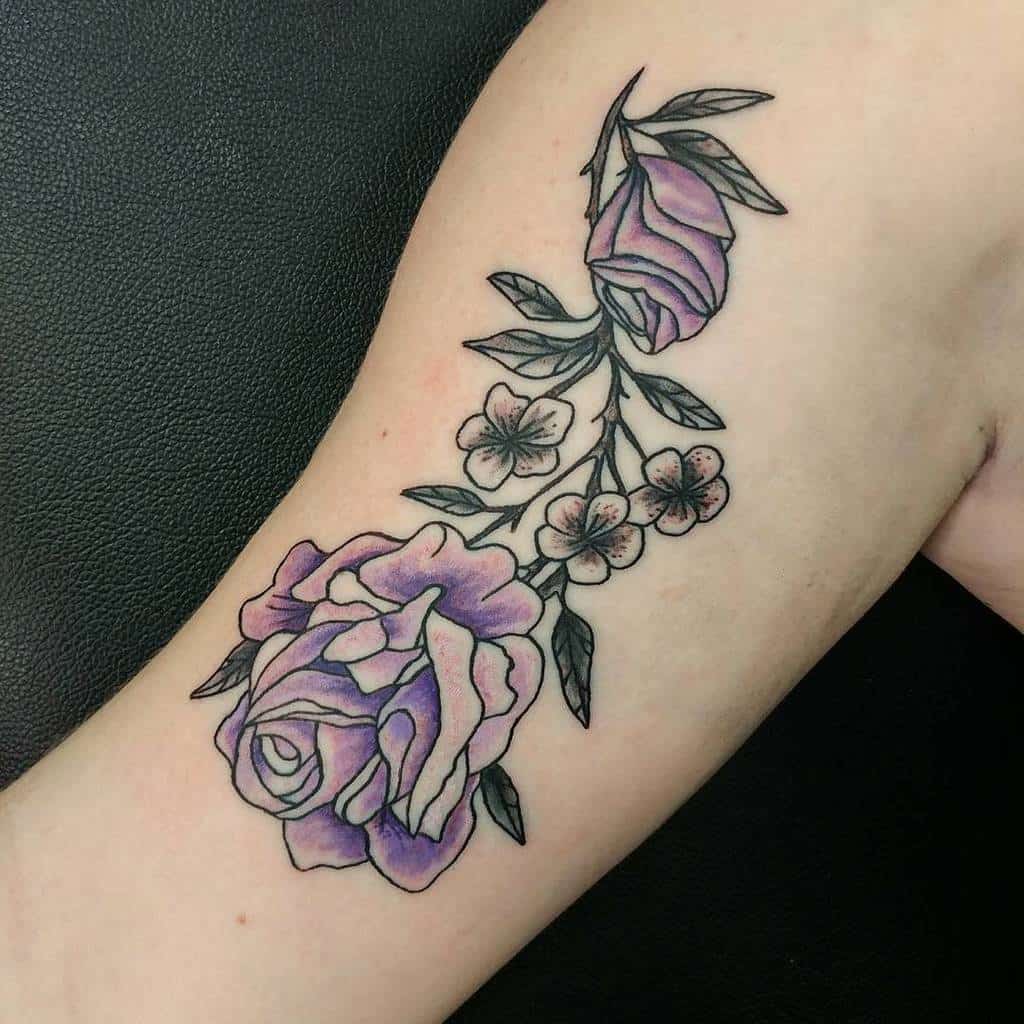 A delicate array of purple roses artfully graces the arm, each flower intricately tattooed to create a stunning masterpiece
