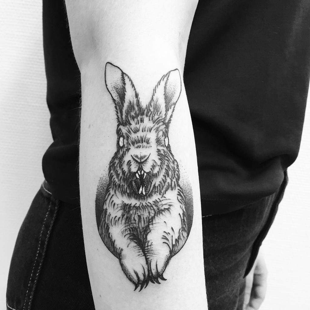 Black and white tattoo of a rabbit, with detailed fur and ears